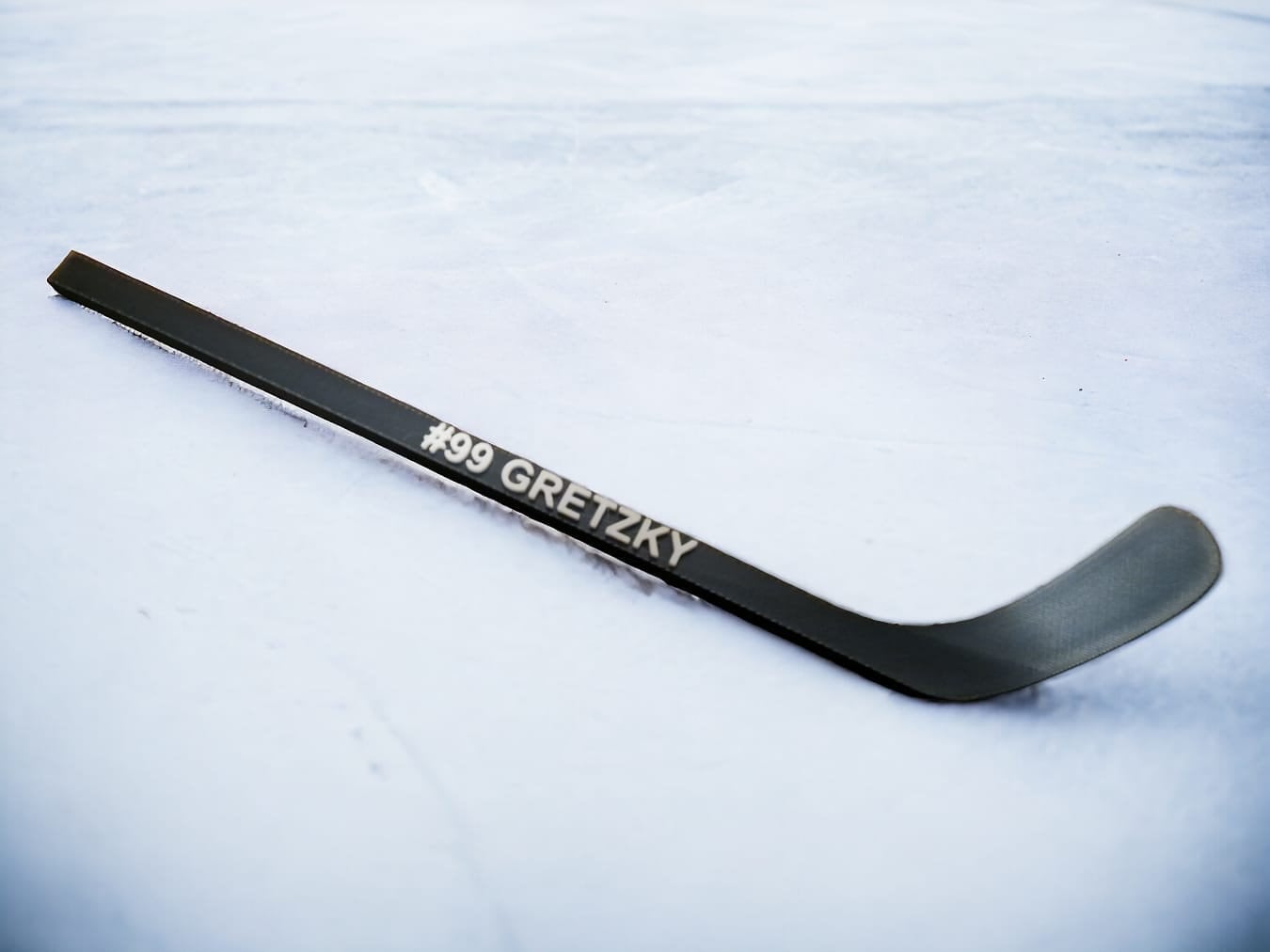 black mini hockey stick with the text "#99 Gretzky" printed on the shaft.