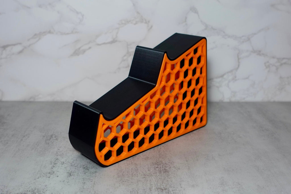 an orange and black holder with a honeycomb pattern on the side.