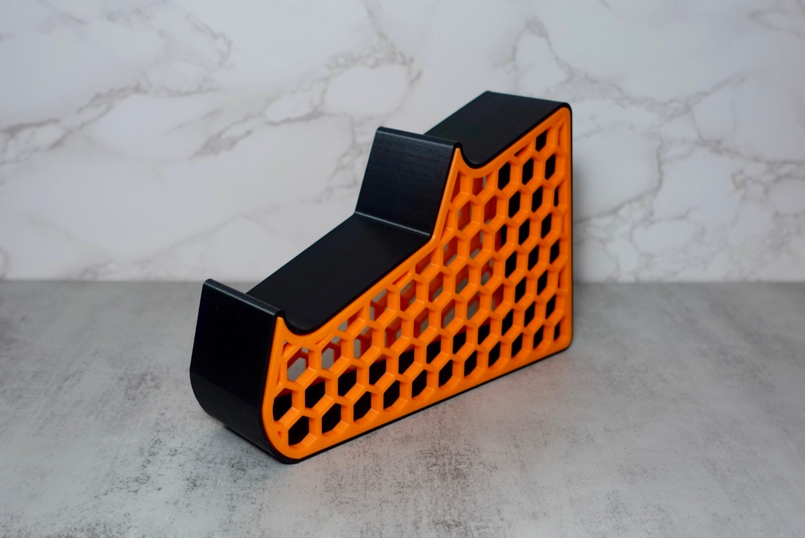 an orange and black holder with a honeycomb pattern on the side.
