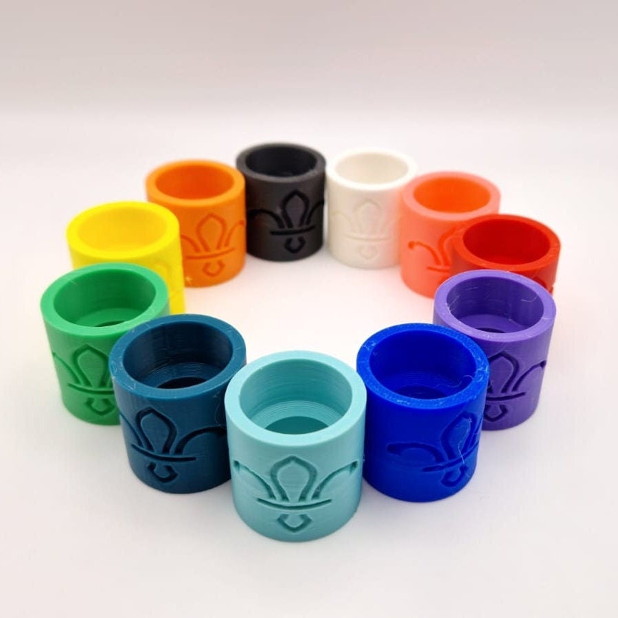 A set of 12 colourful scout woggle featuring a fleur-de-lis design. The woggles are made of plastic and are ideal for beavers, cubs or scouts.